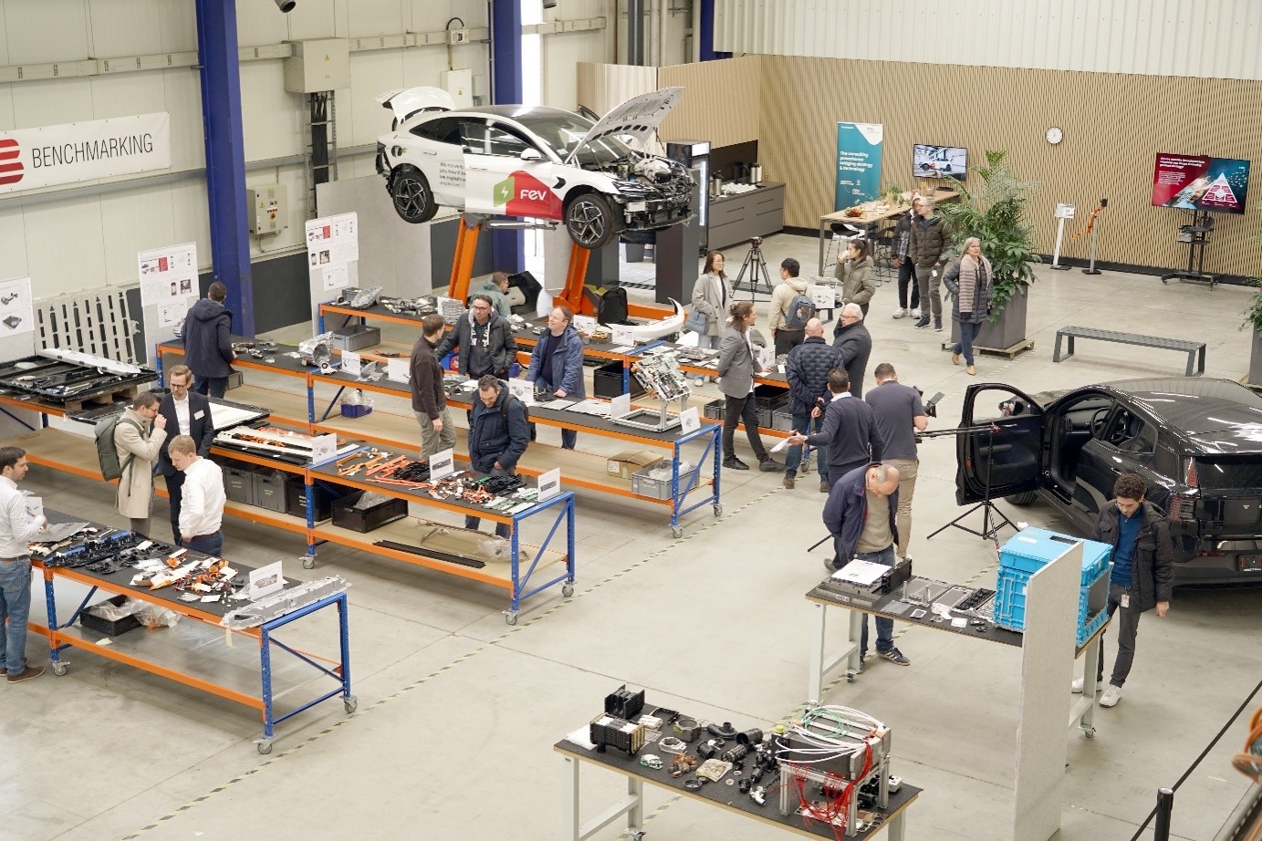 Visitors exploring the FEV Benchmark Center in Aachen, where the FEV Bot humanoid robot is being developed and demonstrated for advanced robotics and functional safety use cases.